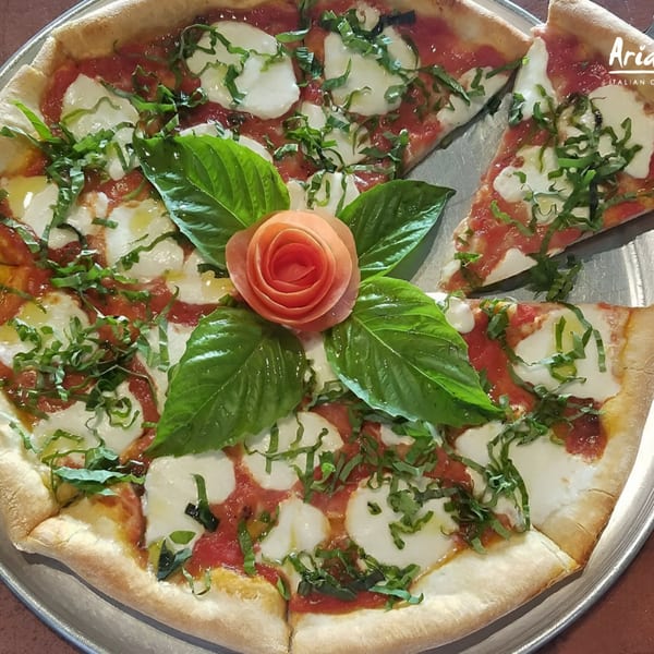 Arianna's Italian Grill Lakeside pizza with fresh mozzarella, basil, and a tomato rose garnish.