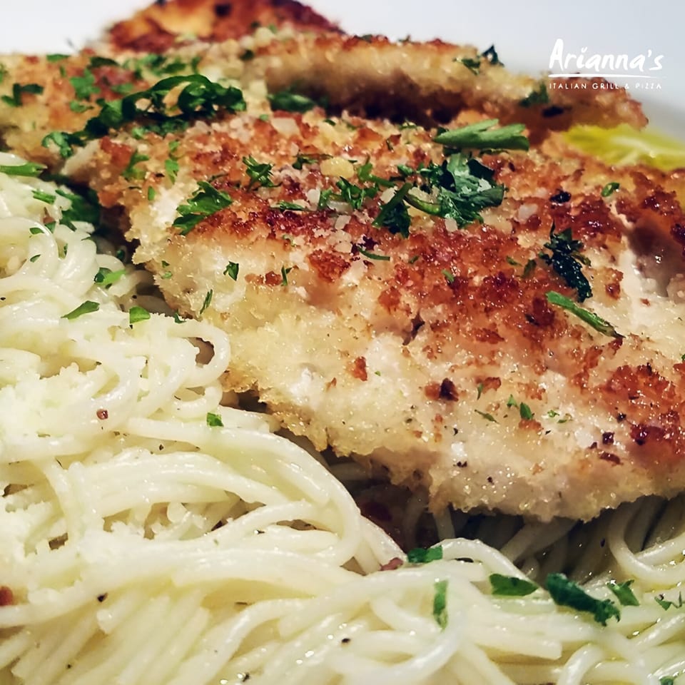 Crispy breaded chicken cutlets with fresh parsley, served over a bed of spaghetti at Arianna's Italian Grill.